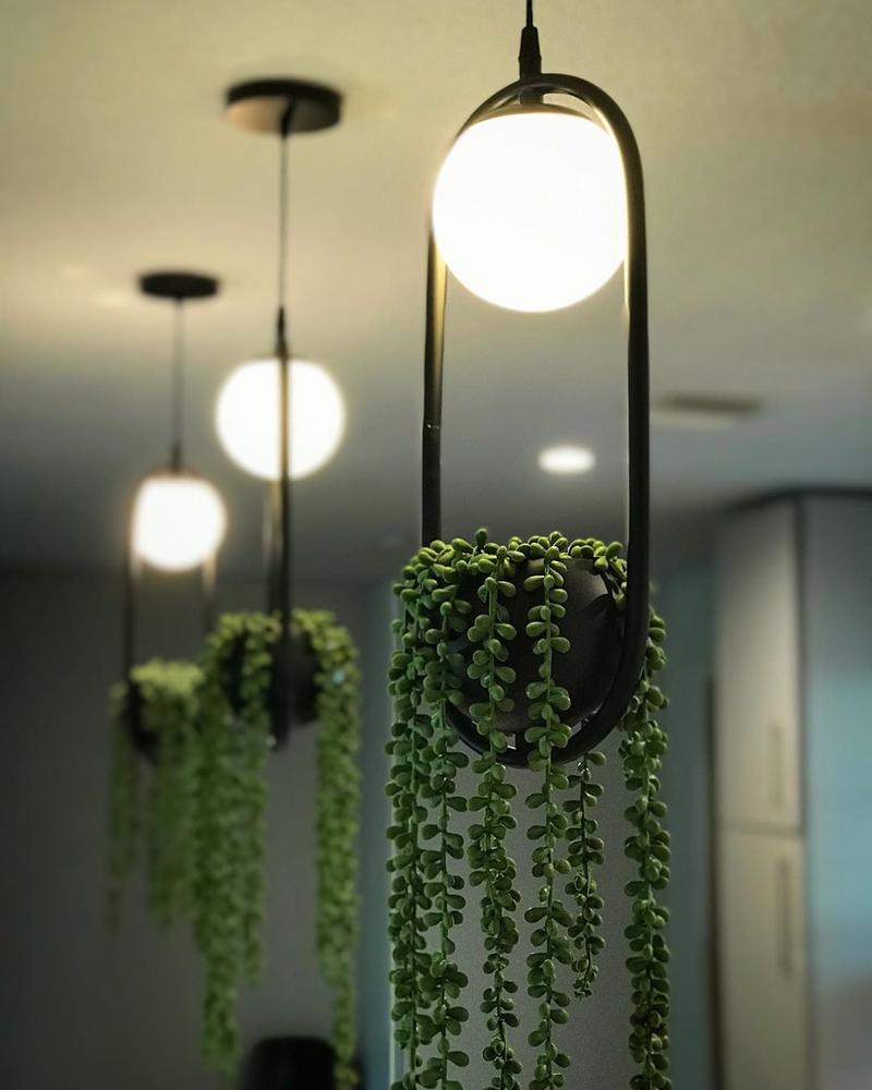 Bloempot hanglamp met zwart armatuur en nep plant